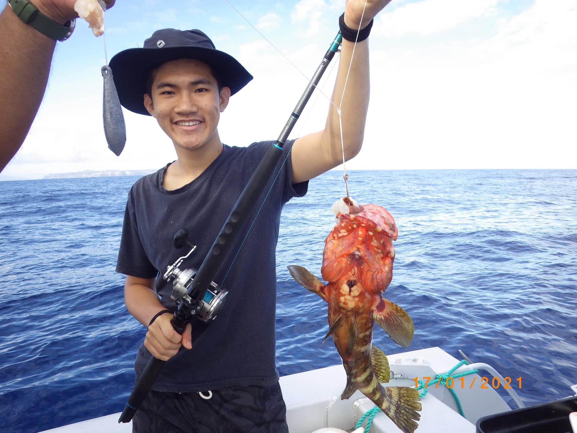 A guest holding his catch during a Norfolk Island fishing trip