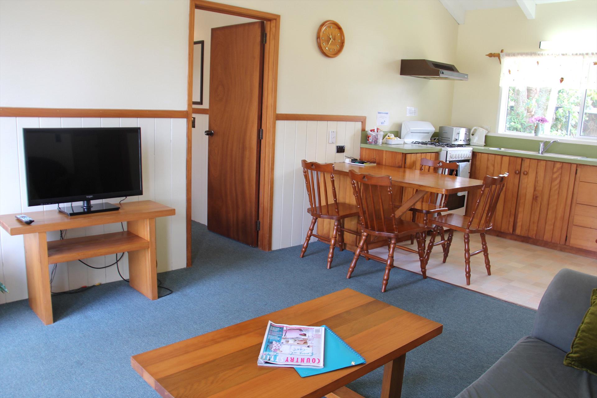 Apartment lounge, dining table and fully equipped kitchen